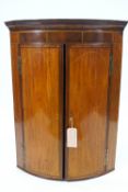 A George III mahogany bow fronted corner cabinet with boxwood and satinwood stringing,