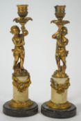 A pair of 19th century gilt metal and alabaster candlesticks in the form of putti