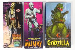 Three Aurora model kits, in boxes and with instructions, Godzilla (in sealed bag),
