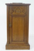 An oak pot cupboard with panelled door on plinth base,