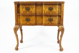 A walnut side table with two drawers on carved cabriole legs with scroll feet,