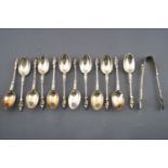 A set of twelve silver Apostle rat tail coffee spoons, and a pair of sugar tongs,