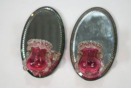 A pair of Victorian cranberry glass posy vases with mirrored backs 20 cm high