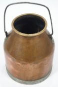 A copper milk churn, of traditional tapered form with applied brass lip and base on an iron handle,