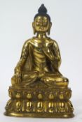 A gilt bronze figure of a Buddha sitting meditating in the lotus position on a shaped base