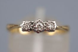 A yellow and white metal three stone diamond ring. Stamped 18ct Plat. Size: K ½ 2.