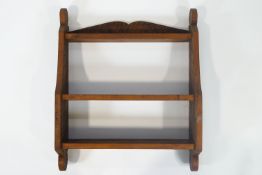 A hanging waterfall book shelf with three tiers, by Geoffrey Juniper,