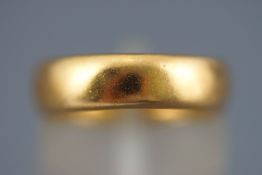 A yellow metal court shaped wedding ring. Hallmarked 22ct gold, Birmingham. Size: J