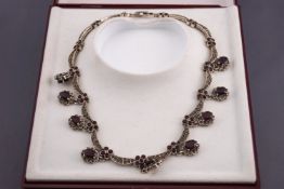 A white metal collar necklace.