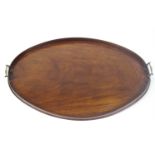 A George IV mahogany oval tray with raised gallery and two brass handles,