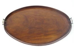 A George IV mahogany oval tray with raised gallery and two brass handles,