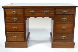 A small Edwardian mahogany kneehole desk with leather inset top