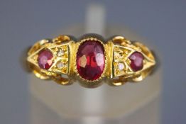 A yellow metal three stone ring set with rubies and rose cut diamonds (one missing).