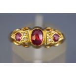 A yellow metal three stone ring set with rubies and rose cut diamonds (one missing).