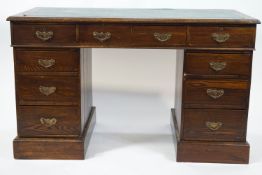 An Edwardian oak pedestal desk with three frieze drawers above three drawers to each pedestal,