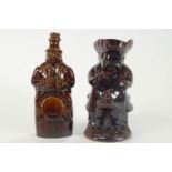 A 19th century pottery treacle glazed Toby jug and a similar gin bottle