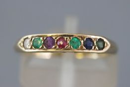 A yellow metal half hoop dress ring set with multi gemstones to spell 'Dearest'.