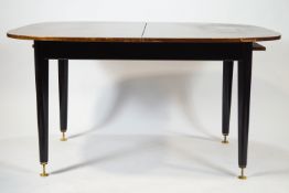 A G-Plan dining table, with one loose leaf on black tapering legs,