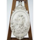 A cast plaster wall plaque, moulded with a classical lady surrounded by Putti,