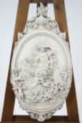 A cast plaster wall plaque, moulded with a classical lady surrounded by Putti,