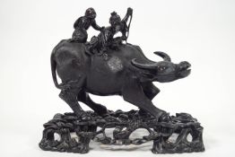 A carved wooden buffalo and stand, in the Chinese style, the buffalo with inset glass eyes,