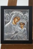 A Russian Tender Mercy Icon of Our Lady and the Christ Child set behind a white metal repousse