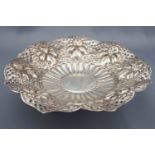 A marked Islamic white metal dish repousse decorated with flowers and fruit in a pierced border