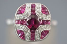 A white metal panel cluster ring set with an oval faceted cut ruby