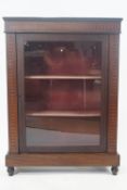 A 19th century mahogany pier cabinet, the glazed door opening to reveal two shelves,