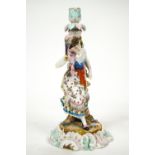 A Continental hard paste porcelain candlestick with a figure of a lady dancing with a fan,