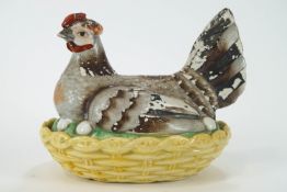 A Victorian Staffordshire pottery hen on a nest, painted in coloured enamels,
