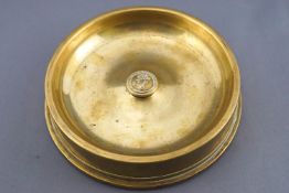 A 1918 brass shell end, 4" 80 calibre, converted to an ashtray, and set a Naval button,