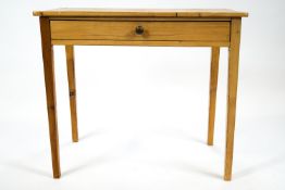 A pine side table with frieze drawer and with plain rectangular top on tapering square legs,