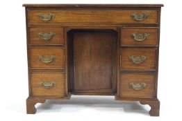 A George III style mahogany kneehole desk with one long drawer above three drawers to either side,