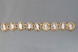 A yellow metal panel bracelet having nine oval links each set with an oval carved shell cameo,
