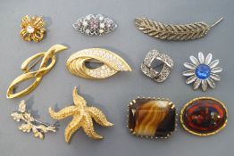 A collection of twenty costume brooches of variable designs.