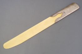 An ivory and silver paper flip, of plain form, the handle formed as a sleeve with a cut out motif,