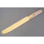 An ivory and silver paper flip, of plain form, the handle formed as a sleeve with a cut out motif,