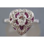 A white metal heart shape cluster ring having a central heart faceted cut diamond