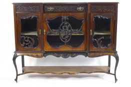 An Edwardian mahogany display cabinet with blind fretwork frieze enclosing one drawer above two