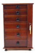 A mahogany and pine collector's cabinet of six graduated drawers with ceramic handles,