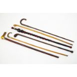Six assorted walking sticks, two with horn handles, and one carved African example,