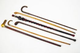 Six assorted walking sticks, two with horn handles, and one carved African example,