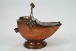 A Victorian copper coal scuttle of contrived nautilus shell form,