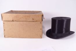 A leather hat box with a black felt Top hat,