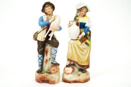 A pair of German slip cast bisque figures in traditional dress,