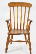 An elm and ash stick back elbow chair with solid seat and turned legs linked by stretchers