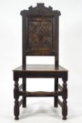 A Tudor style chip carved oak chair with a shaped cresting rail over a central quatrefoil panel