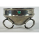 An Arts and Crafts style pewter bowl with inset turquoise coloured cabouchons set to the rim,