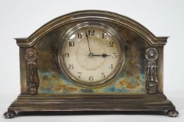 An early 20th century mantel clock in silver plated case on bun feet, 15.